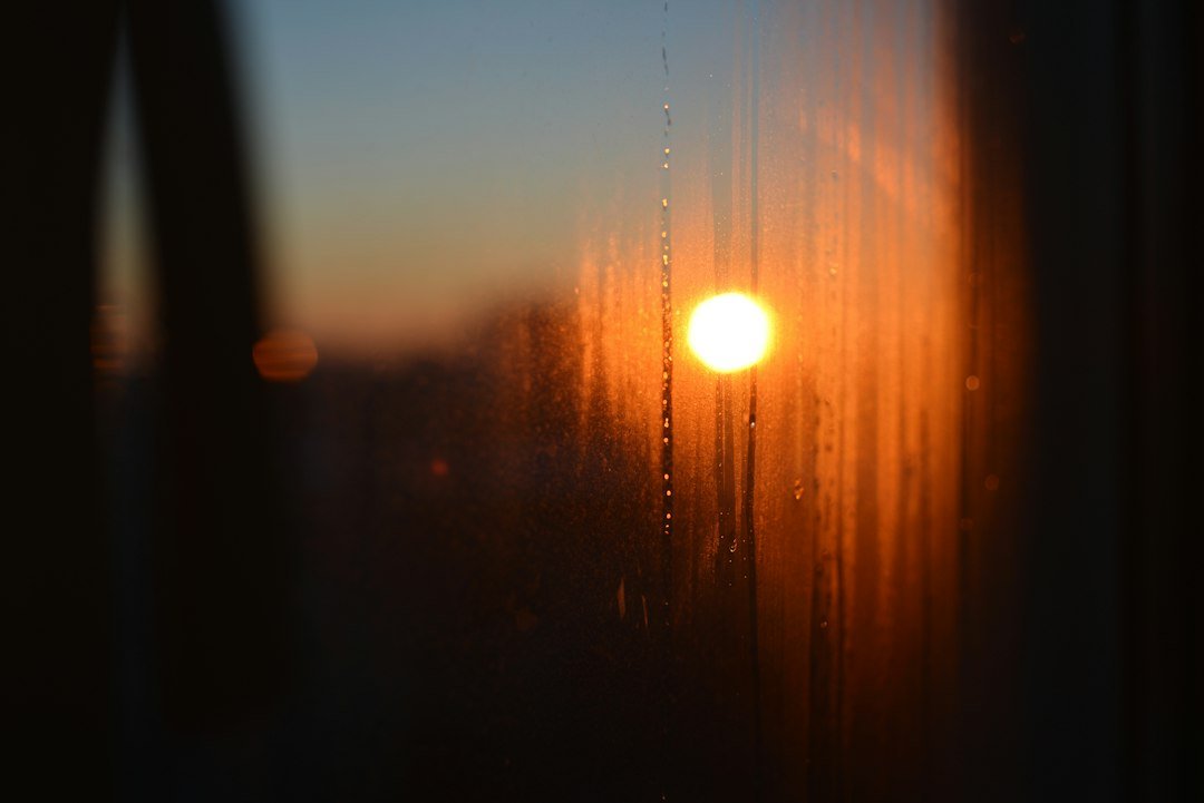 Luz de setembro vista através de uma janela com gotas