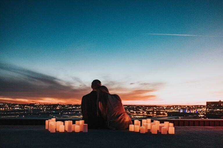Casal sentado junto à luz de velas durante a noite