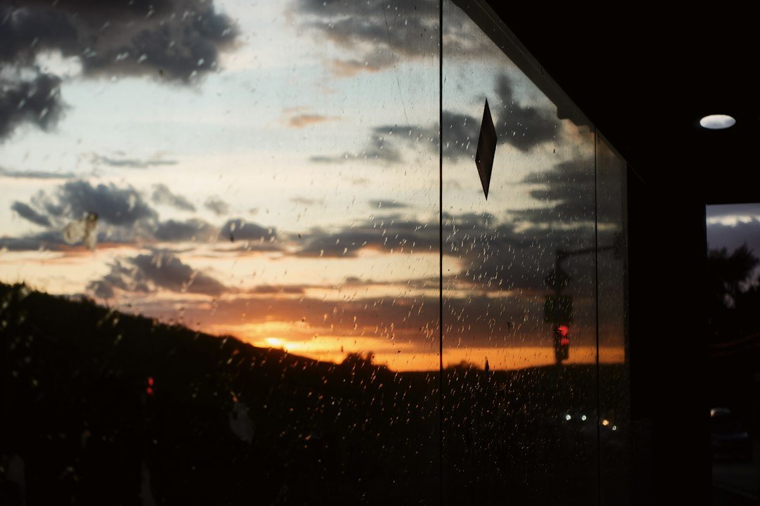 Amanhecer através de uma janela molhada pela chuva