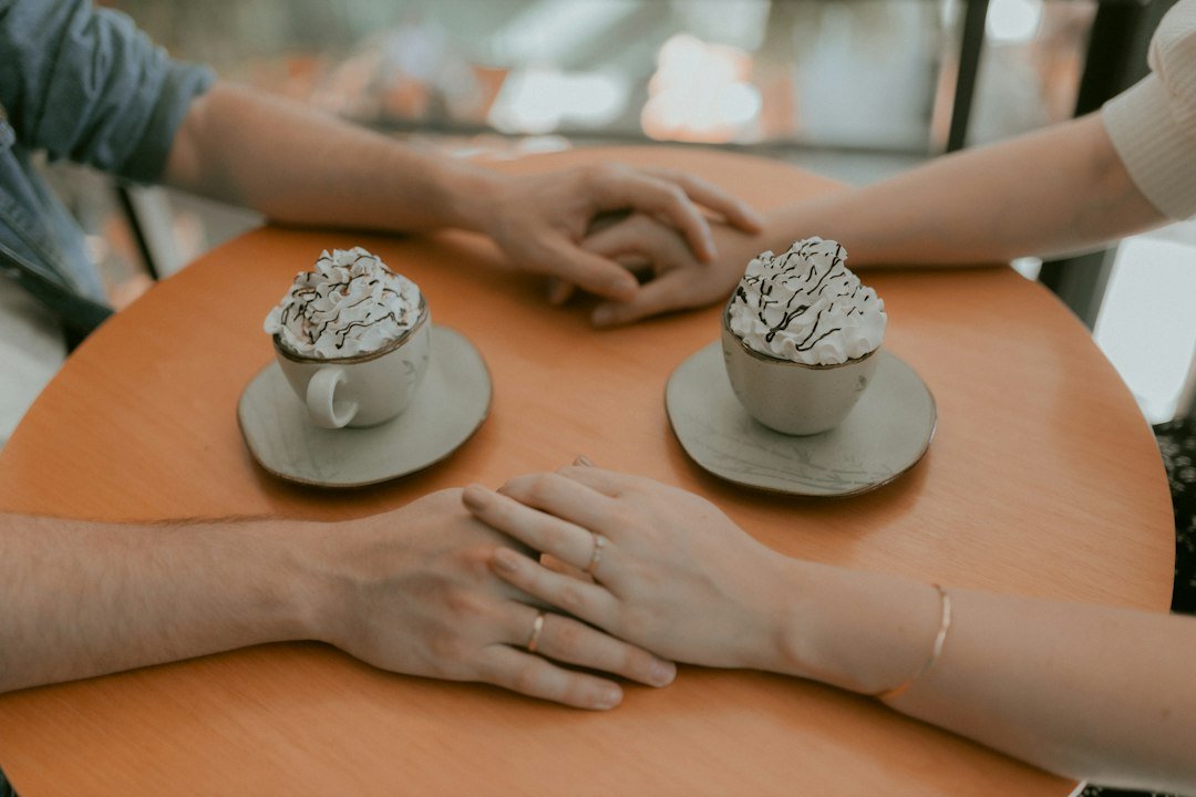 Duas pessoas de mãos dadas durante um café