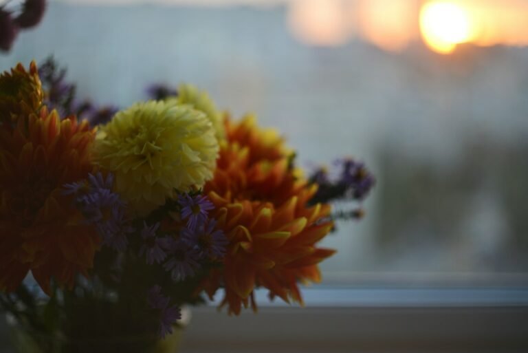 Vaso com flores coloridas sobre o parapeito de uma janela