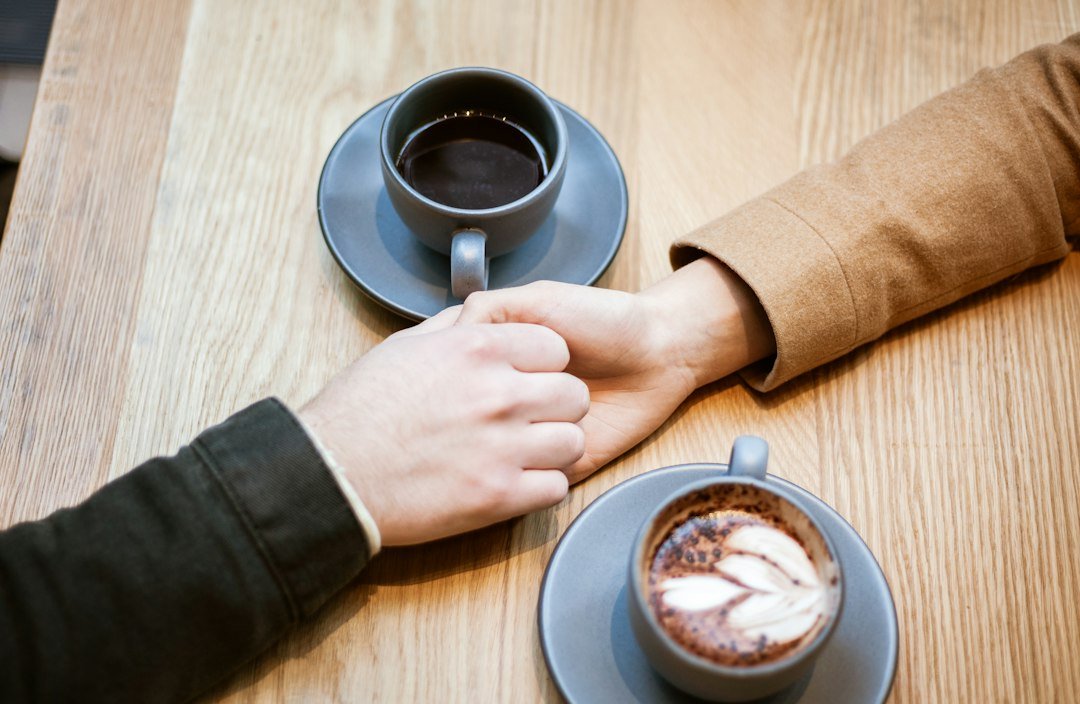 Frases de Deus Curtas e Bonitas: 58 Mensagens de Fé 1 Duas pessoas de mãos dadas entre xícaras de café sobre a mesa