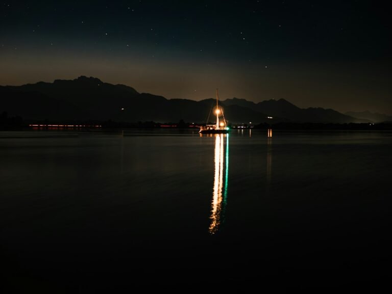 Mensagem de Boa Noite com Sabedoria: 42 Reflexões 4 Barco iluminado refletido em um lago calmo durante a noite