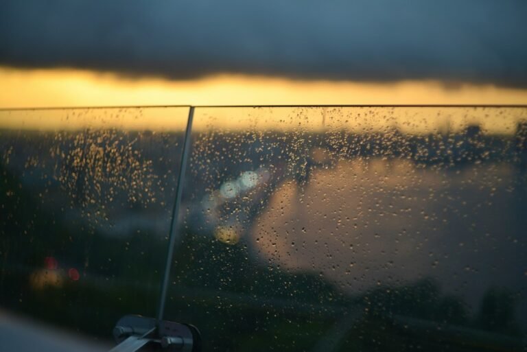 Gotas de chuva no vidro com luz suave ao fundo