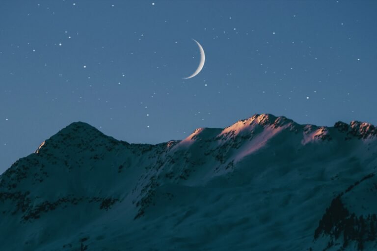 Lua crescente acima de montanhas durante uma noite serena